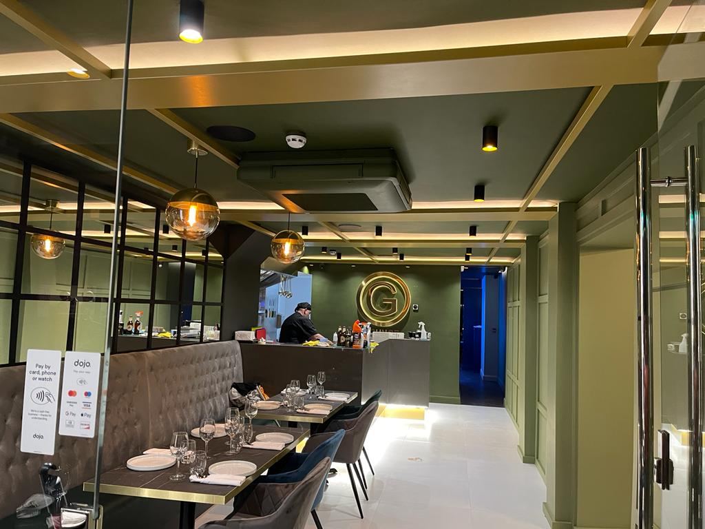 G Lounge: front dining room with the branded gold G feature wall