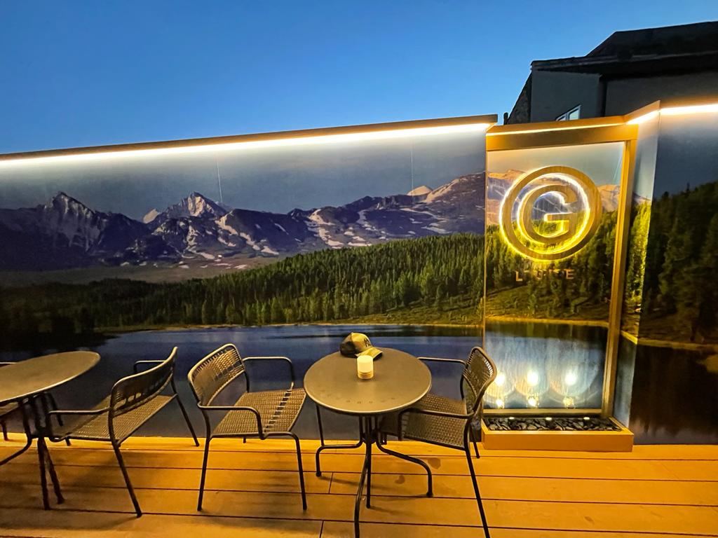 G Lounge: covered garden terrace with illuminated feature wall