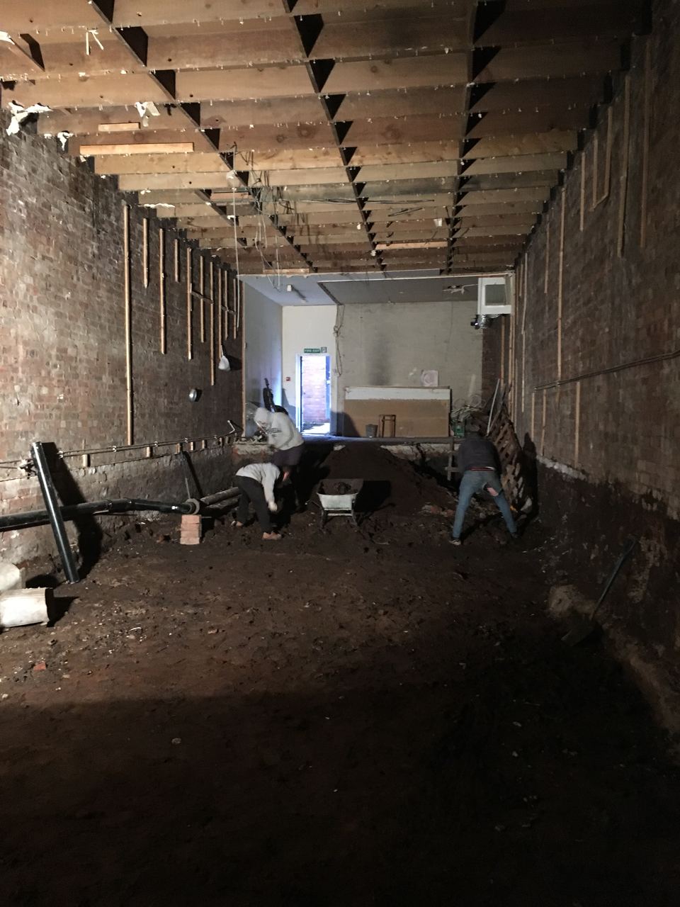 The unit gutted back to bare brick with the floor removed.